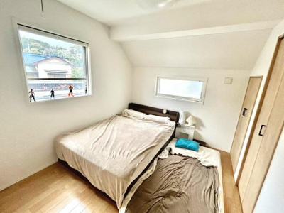 シンプルで清潔感のある寝室です。2つの窓から自然光が入り明るい空間が広がります。収納スペースも備え付けられており整理整頓がしやすいです。ベッドの横にサイドテーブルが設置されていて便利です。