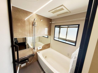 ゆったりとした浴槽でくつろげるバスルームです。大きな窓があり開放感があります。壁面収納が設けられており使いやすい設計です。床材は滑りにくく安心してご利用いただけます。