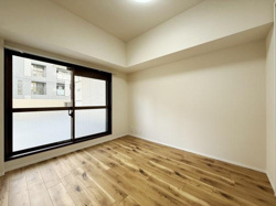 明るい色合いのフローリングが特徴的な洋室です。大きな窓から光が入り室内が明るく感じられます。壁・天井ともにシンプルなデザインなので様々なインテリアに合わせやすい空間です。