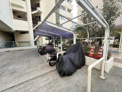 屋根付きのバイク置き場があり天候の影響を受けにくい設計です。複数台のバイクを駐車できるスペースが確保されています。敷地内に設置されているため便利に利用できます。周囲も広めで駐車しやすいです。