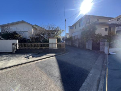 前面道路がしっかり整備されており車の出入りもスムーズに行えます。周辺には住宅が立ち並び落ち着いた雰囲気が広がっています。日当たりも良好で現地の状況がよく分かる写真です。