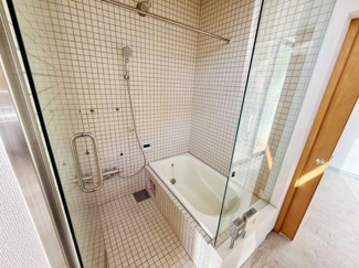 ガラス張りのデザインが印象的な洗面所です。タイル張りの壁や床が清潔感を演出します。浴槽とシャワーが一体になった空間で使い勝手も良好です。自然光が差し込む明るい雰囲気が魅力です。