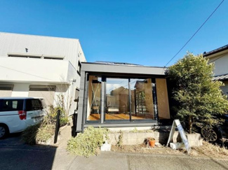 大きな窓から光が差し込む印象的な外観です。前面道路との接道もスムーズで車の出入りも便利です。シンプルなデザインが建物の個性を引き立てています。隣家との距離感も程よくゆとりを感じられます。