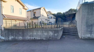 高台に位置する敷地で道路からの視線が気になりにくい外観です。開放感のある前面スペースも魅力的です。周辺の住環境も落ち着いた印象です。ゆとりあるアプローチも特徴です。