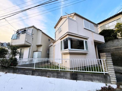 明るい外観が印象的な戸建です。2階建ての設計で十分なプライバシーを確保できます。角度のある出窓やバルコニー付きで開放感も感じられます。玄関前の階段やフェンスも整えられた印象です。