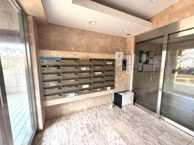 エントランス部分は明るく清潔感があります。ポストが整然と配置され管理状況がうかがえます。ガラス扉越しに外の様子も見やすくなっています。掲示板や宅配ボックスが設置されているのも特徴です。