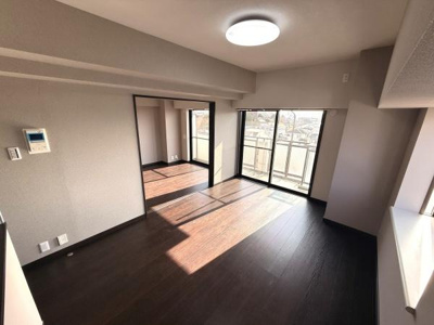 リビングは大きな窓から光が差し込み室内が明るく感じられます。落ち着いた色合いのフローリングが静かな雰囲気を演出しています。隣接する部屋とのつながりもあり空間を広く使えます。