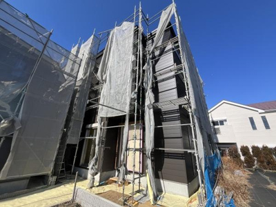 建物外観は現代的なデザインで洗練された印象があります。しっかりとした工事が進行中で細部にまで配慮を感じられます。青空に映える外壁カラーが外観の魅力を引き立てています。