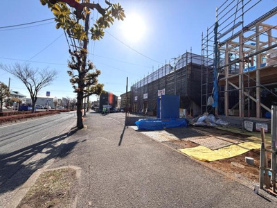 前面道路は広々としており見通しの良さが感じられます。歩道もしっかり整備されているため安心感があります。建物の工事も進んでおり周囲は清潔に保たれています。立ち並ぶ樹木が景観にアクセントを加えています。