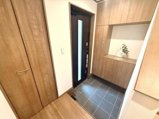 玄関スペースが広く収納がしっかり確保されています。木目調のデザインが温かみを感じさせます。シンプルな内装でお手入れもしやすい玄関です。落ち着いた雰囲気の空間が広がっています。