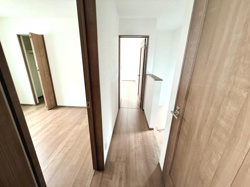 明るい色調のフローリングが空間を広く感じさせます。複数の部屋へのアクセスがしやすい間取りです。白基調の壁で清潔感が感じられます。各部屋にドアが設置されているため独立性も確保されています。