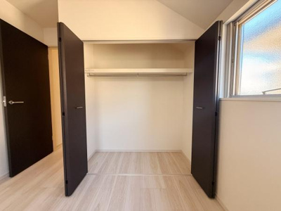 両開きの扉が広々とした収納スペースを演出しています。棚とハンガーパイプが設置されており使い勝手が良い印象です。窓から自然光が入り収納内も明るさが保たれます。室内全体をすっきりと見せることができます。