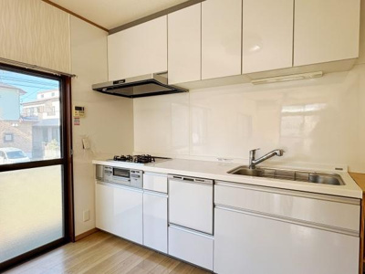 白を基調としたキッチンが空間全体を明るく見せます。収納スペースが豊富なので整理整頓にも便利です。大きなシンクと広い作業スペースが使いやすく窓からの採光で室内が爽やかな印象になります。