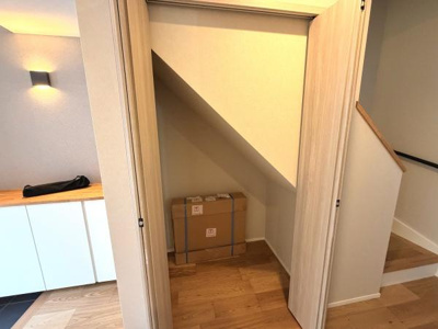 階段下の空間を有効活用した収納スペースです。扉付きで普段使わないものもすっきりしまえます。玄関や廊下の近くに位置し出し入れしやすい設計になっています。シンプルな内装で他のインテリアとも調和します。