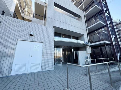 タイル張りの外観が特徴的なマンションです。エントランスには手すりが設置されています。広々としたアプローチが印象的です。ガラス張りの扉で明るい印象があります。敷地内は清潔感が保たれています。