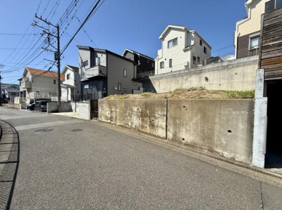 現地写真よりゆったりとした前面道路が広がり開放感があります。周囲には住宅が立ち並び街並みに溶け込んだ環境です。晴れた日には青空がしっかりと見渡せます。