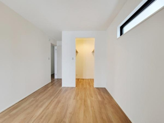 明るい光が差し込む洋室です。シンプルな内装で様々なレイアウトに対応できます。ナチュラルなフローリングが空間を引き立てます。収納スペースも確保されています。清潔感のある雰囲気でご利用いただけます。