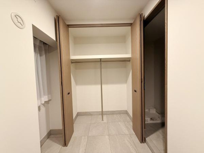 収納スペースが広く設計されており整理整頓がしやすいクローゼットです。両開きの扉で使い勝手が良い点も魅力です。上段には棚も備え付けられており小物の収納にも便利です。室内の明るさも確保されています。