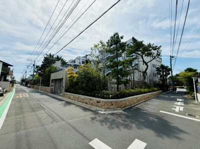 開放感のある歩道が印象的な外観です。建物の外壁やガラス手すりがスタイリッシュな雰囲気を演出しています。緑豊かな植栽も整備されていて歩くのが楽しくなります。