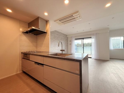 開放感のあるキッチンが特徴的です。シンプルで洗練されたデザインが印象的です。窓からの光がキッチンエリアまでしっかり届きます。リビングと一体の空間で使いやすさに配慮されています。