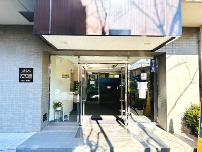 ガラス扉を採用したエントランスは明るく開放感のある印象です。植栽やサインが配置されていて全体的に落ち着いた雰囲気を感じられます。清潔感のある仕上がりで来訪者を迎える空間として整っています。