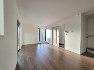 明るい光が差し込む広々としたリビング空間です。落ち着いた木目調のフローリングが室内を柔らかく演出します。大きな窓が印象的で開放感が感じられます。階段も近く移動がスムーズです。