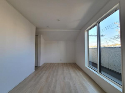 大きな窓から自然光が入る明るい洋室です。シンプルな内装で使いやすい空間です。床は落ち着いた色調のフローリング仕上げです。収納スペースも設けられており便利です。ゆったりとした広さが感じられます。