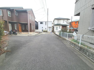 幅広い前面道路が特徴的な現地写真です。周辺は新しい住宅が並び落ち着いた雰囲気が伝わります。周囲の街並みや建物もよく整えられておりすっきりとした印象です。敷地前のスペースも広めに確保されています。