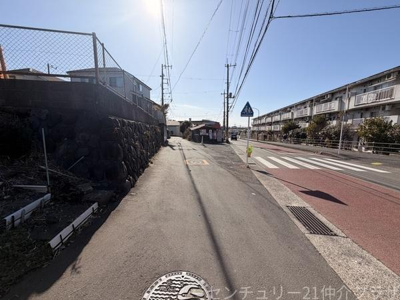 現地前面道路は幅員が確保されており車の通行もスムーズに行えます。歩道も整備され周辺は住宅が立ち並ぶ落ち着いた雰囲気です。道路沿いには横断歩道や標識もあり安全面にも配慮されています。