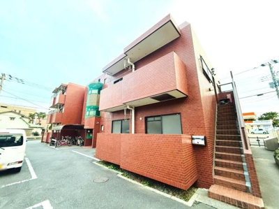 レンガ調の外観が特徴的なマンションです。敷地内には駐輪スペースが確保されています。共用階段は外からの出入りがしやすい設計です。全体的に明るい印象があります。
