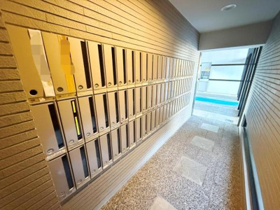 共用部に多数のメールボックスが設置されています。仕切りのあるデザインで個別に郵便物を管理できます。エントランスからのアクセスもスムーズです。清潔感のある明るい内廊下です。