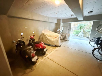 バイクや自転車が安心して置ける屋内の駐輪スペースです。雨風の影響を受けにくく日常の利用にも便利です。コンクリート造のためしっかりとした造りが感じられます。敷地内に複数台分のスペースが確保されています。