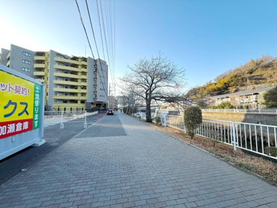 広々とした歩道が続き季節によって表情が変わる街路樹も楽しめます。川沿いにはフェンスが設置されており安心感のある歩行環境です。周辺にはマンションや建物も多く静かな住宅街の雰囲気が感じられます。