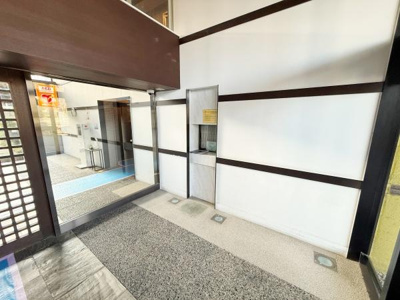 エントランスはガラス扉で明るく開放的な空間です。壁面にアクセントとなるラインが施されデザイン性が感じられます。床材は異素材が組み合わされており印象的な雰囲気です。