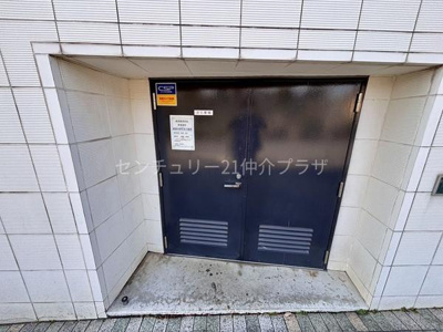 堅牢な印象の扉で安心感があります。周囲はタイル張りで清潔な雰囲気です。建物の一角にしっかりと設けられた出入り口となっています。ドアには換気口が設置されており空気の流れにも配慮されています。