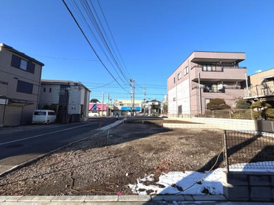 日当たりの良い現地土地写真です。前面道路に面しており交通の利便性を感じられる場所です。周辺には住宅もあり落ち着いた街並みが広がっています。
