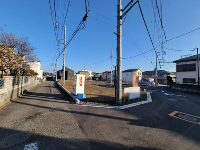 前面道路がしっかり整備されており車でのアクセスもスムーズです。周辺は住宅が建ち並び落ち着いた雰囲気が感じられます。直線で見通しが良く安全面にも配慮されています。現地の状況が一目で確認できる写真です。