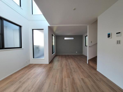 大きな窓から自然光がたっぷり入るリビングです。落ち着いた色合いのフローリングが空間を引き締めています。天井が高く開放感があります。シンプルなデザインがインテリアを引き立てます。