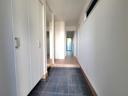 玄関は明るい空間で収納が充実しています。シンプルなデザインで清潔感があります。タイル床が使いやすく全体にゆとりある印象です。正面には廊下が続いており開放感があります。