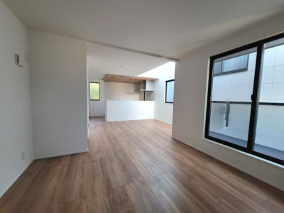 リビングには大きな窓があり自然光がしっかり入ります。木目調のフローリングが上品な雰囲気を演出しています。壁と天井はホワイトでまとめられ開放的な空間を実現しています。清潔感のある内装が印象的です。