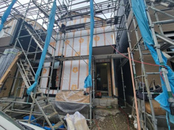 建築途中の外観が確認でき全体の構造や広がりが見て取れます。足場が設置され工事の進行具合を実感できます。外壁下地材の様子や玄関周りの仕様も分かりやすいです。