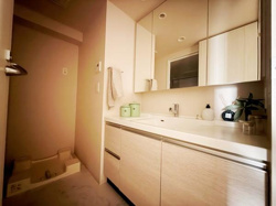 洗面台・洗面所は広々としたカウンターと収納スペースが特徴です。三面鏡が付いており身支度がしやすい設計になっています。明るい照明と清潔感のある内装が印象的です。