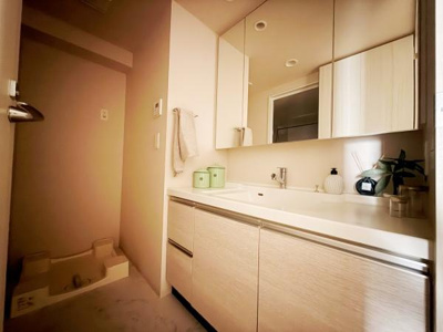 洗面台・洗面所は広々としたカウンターと収納スペースが特徴です。三面鏡が付いており身支度がしやすい設計になっています。明るい照明と清潔感のある内装が印象的です。