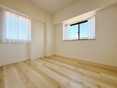 明るい光が差し込む洋室でシンプルな内装が特徴です。ナチュラルなフローリングが空間を広く見せます。窓が2面あり換気もしやすいつくりです。