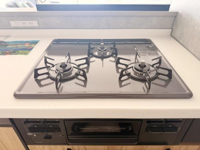 三口のガスコンロが設置されており調理スペースがしっかり確保されています。グリル付きの仕様で様々な料理に対応できるレイアウトです。