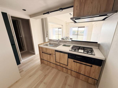 木目調のデザインが特徴のキッチンです。リビングとのつながりを感じられるレイアウトです。