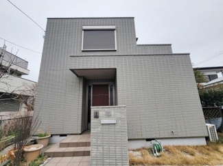 シンプルなデザインが特徴的な外観です。玄関アプローチが広くゆとりがあります。シャッター付きの窓が設置されています。プランターなども配置できるスペースがあります。芝生のお庭付きで多用途に利用できます。