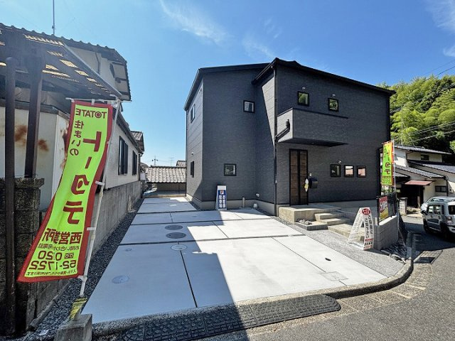 落ち着いたダークカラーで統一された外観。角地に面しており、建物まわりに開放感が感じられる配置です。