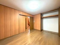 木目調の壁面が温かみを感じさせるお部屋です。広々としたクローゼットが備わっており衣類や日用品の整理に便利です。天井照明が明るく落ち着いた雰囲気の空間となっています。