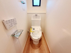 清潔感のあるトイレ空間です。窓があり換気がしやすい設計となっています。床材の色合いが柔らかく全体的に明るい印象です。シンプルですっきりとした内装です。
